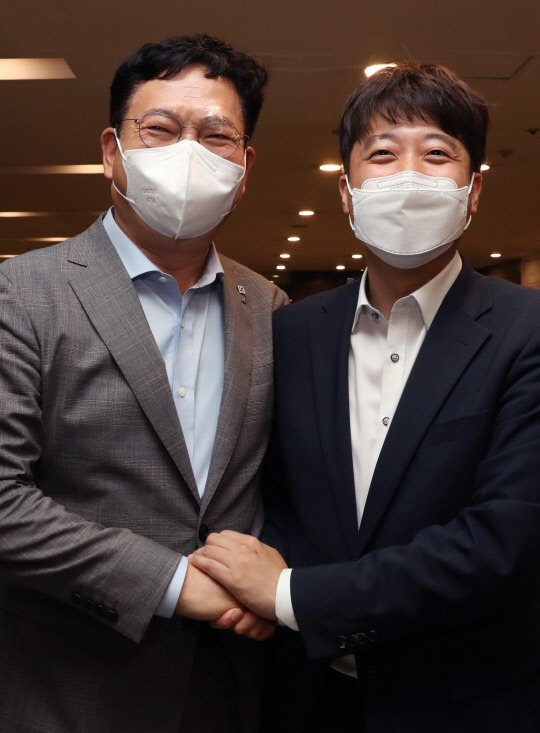 12일 송영길 더불어민주당 대표(왼쪽)와 이준석 대표(오른쪽)가 서울 여의도의 한 식당에서 만찬한 뒤 손을 잡고 있다. 연합뉴스.